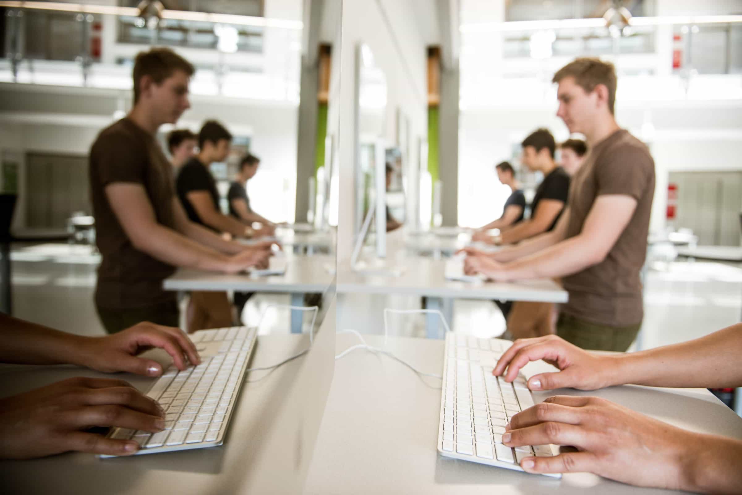 Bild mit Studierenden, die eine Computertastatur bedienen.